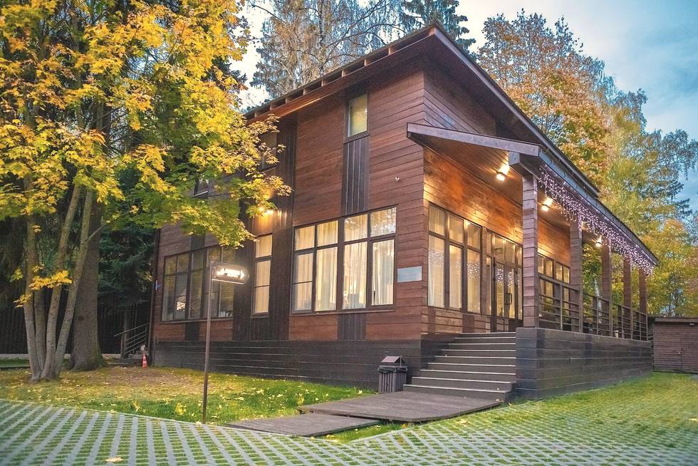 Зал для практик — деревянное здание с панорамными окнами в лесу